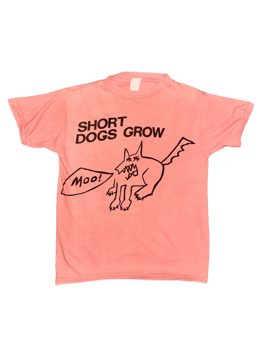 Coral t-shirt with black text and Short Dogs Grow graphic on a white background