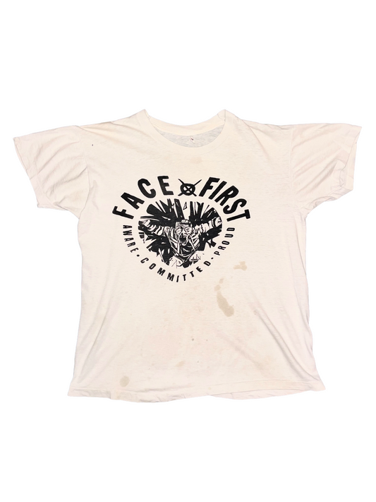 Beige t-shirt with black "Face First" graphic design and text on a white background